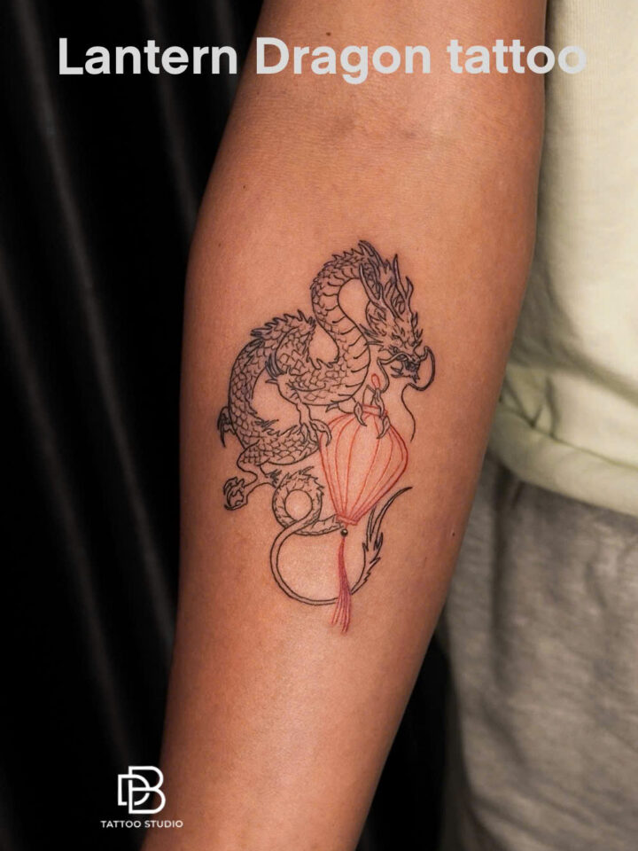 Mini dragon curled around a red lantern on a forearm