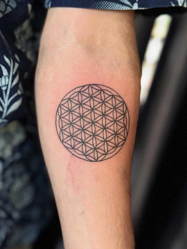Flower of life geometric circle tattooed on a forearm