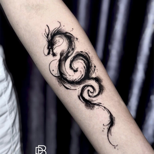 Brush stroke ink dragon tattooed along a forearm