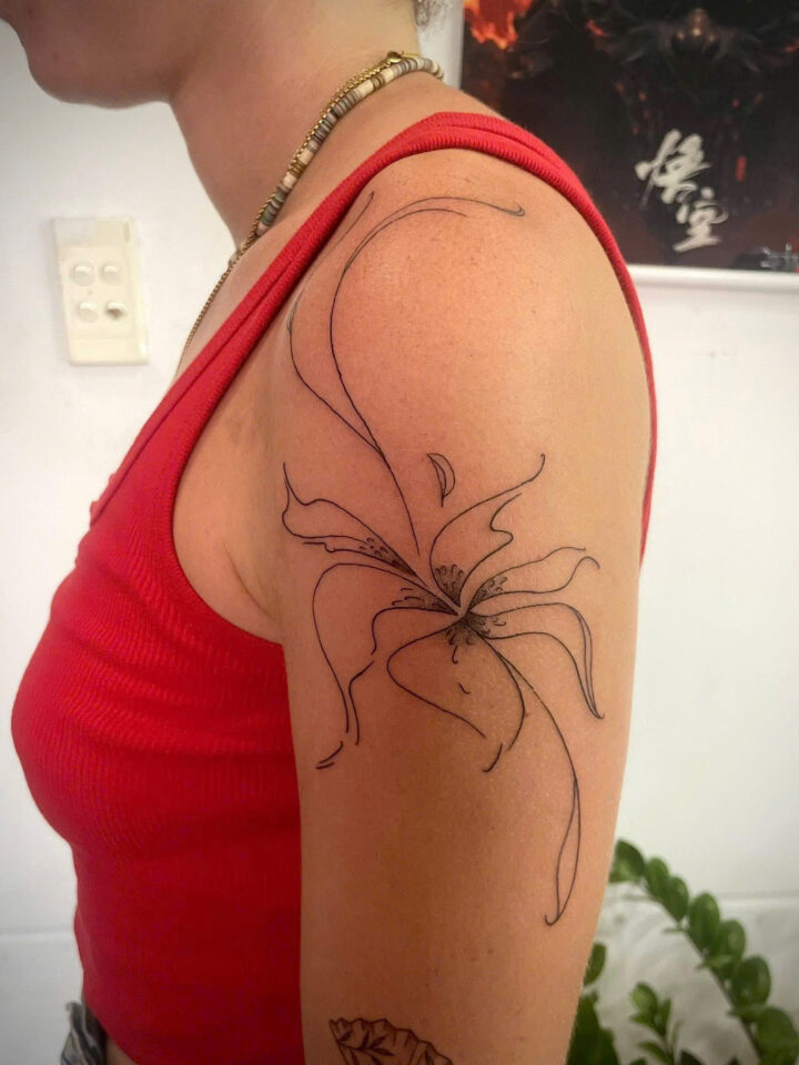 Large fine line spider lily flowing across a shoulder