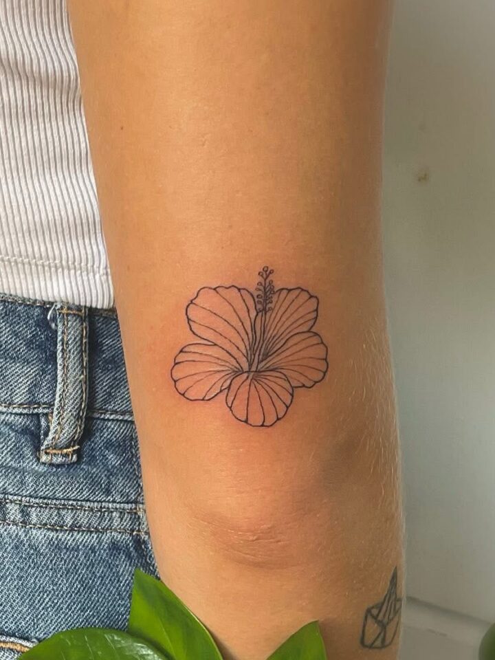 Small hibiscus outline tattoo on the back of an arm