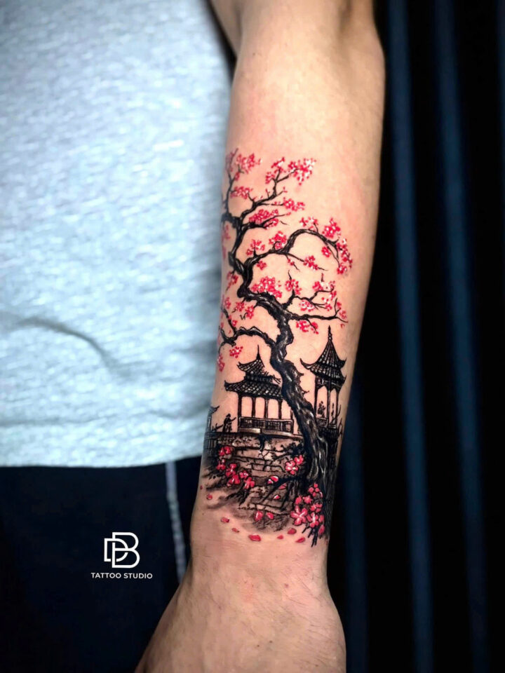 Cherry blossom tree and pagoda tattooed in pink and black on a forearm