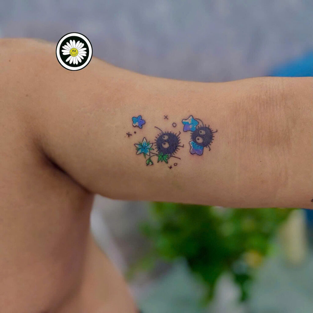 Small colour soot sprite tattoos with stars on an inner arm