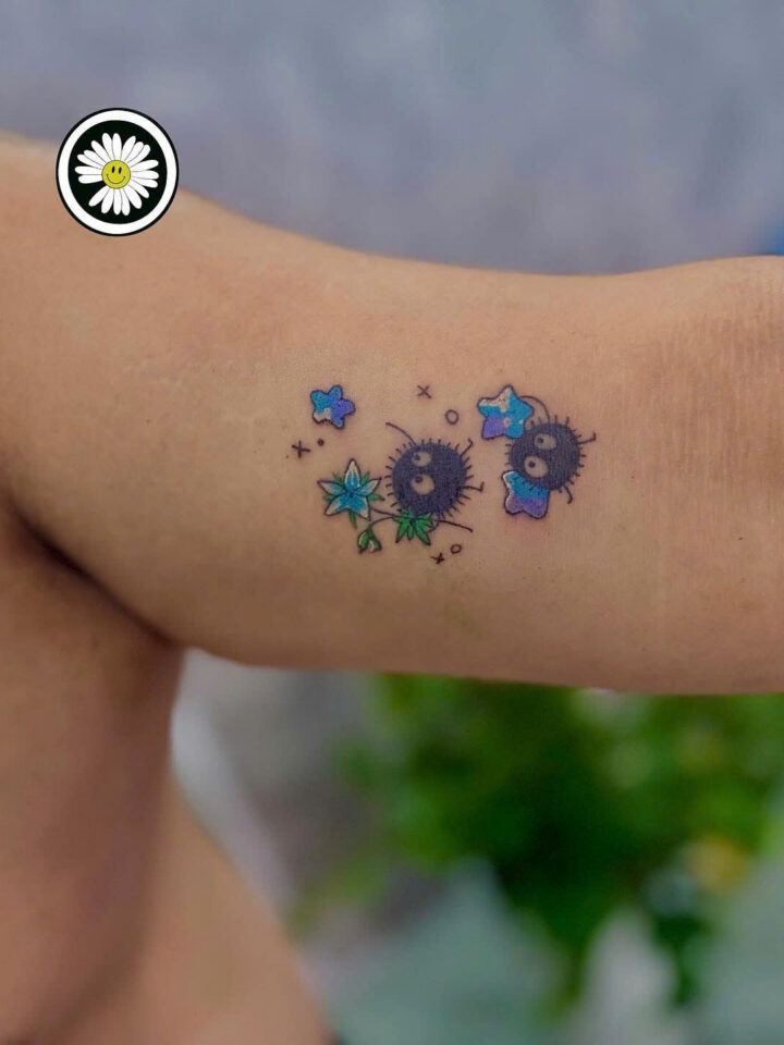 Small colour soot sprite tattoos with stars on an inner arm