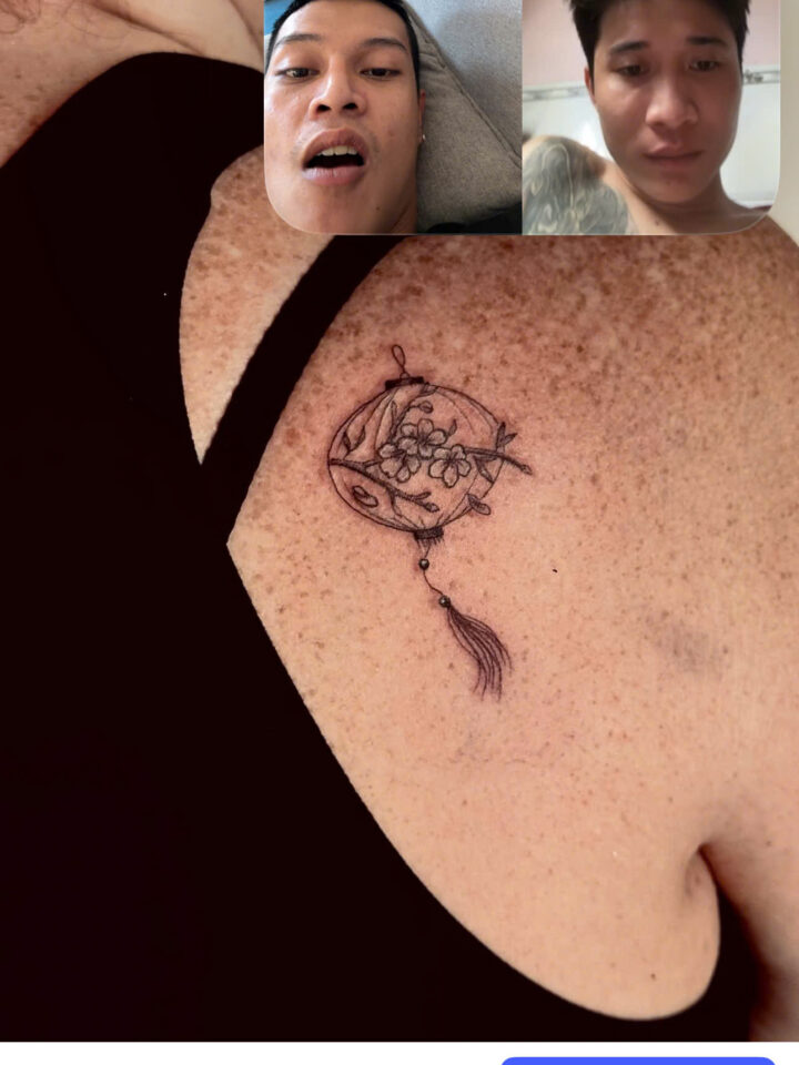 Client showing a new Vietnamese tattoo on a video call with DanBam Tattoo