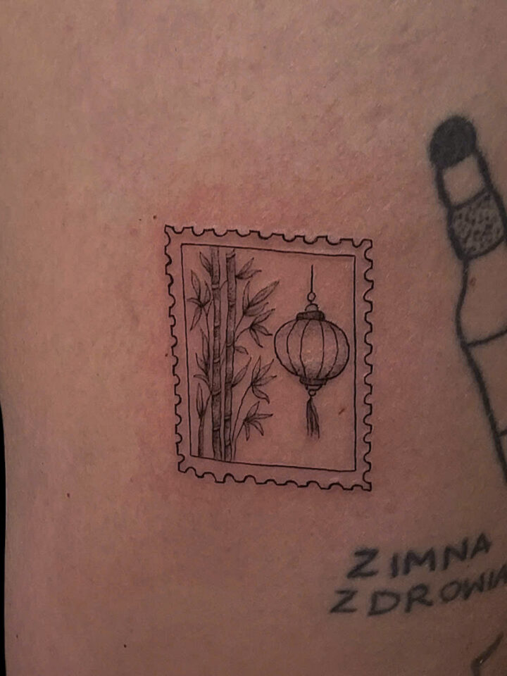 Postage stamp tattoo of bamboo and a Hoi An lantern on a thigh