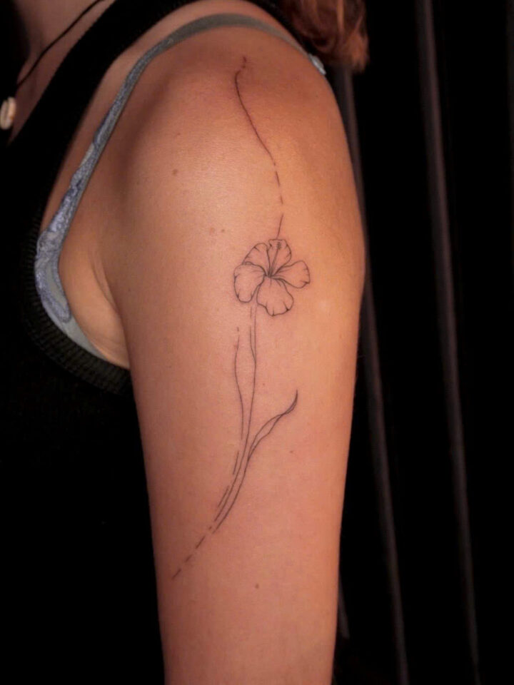 Single fine line flower tattooed down the upper arm